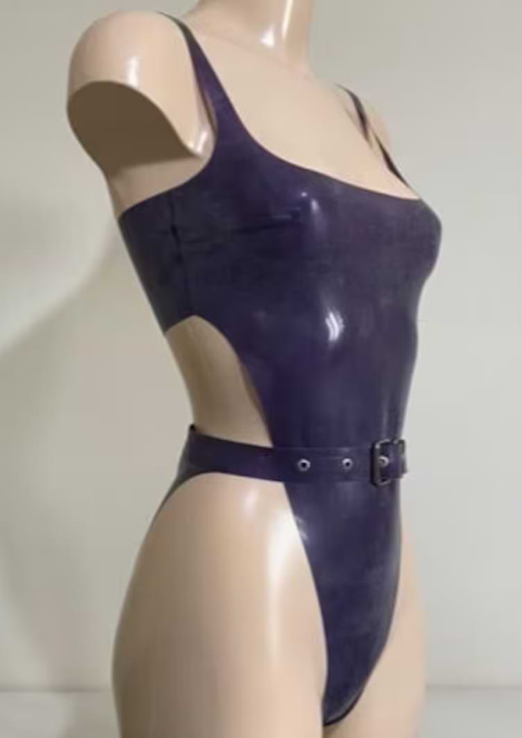 Side view of a mannequin wearing a deep purple latex bodysuit with high-cut hips, a square neckline, and a matching belted waist.